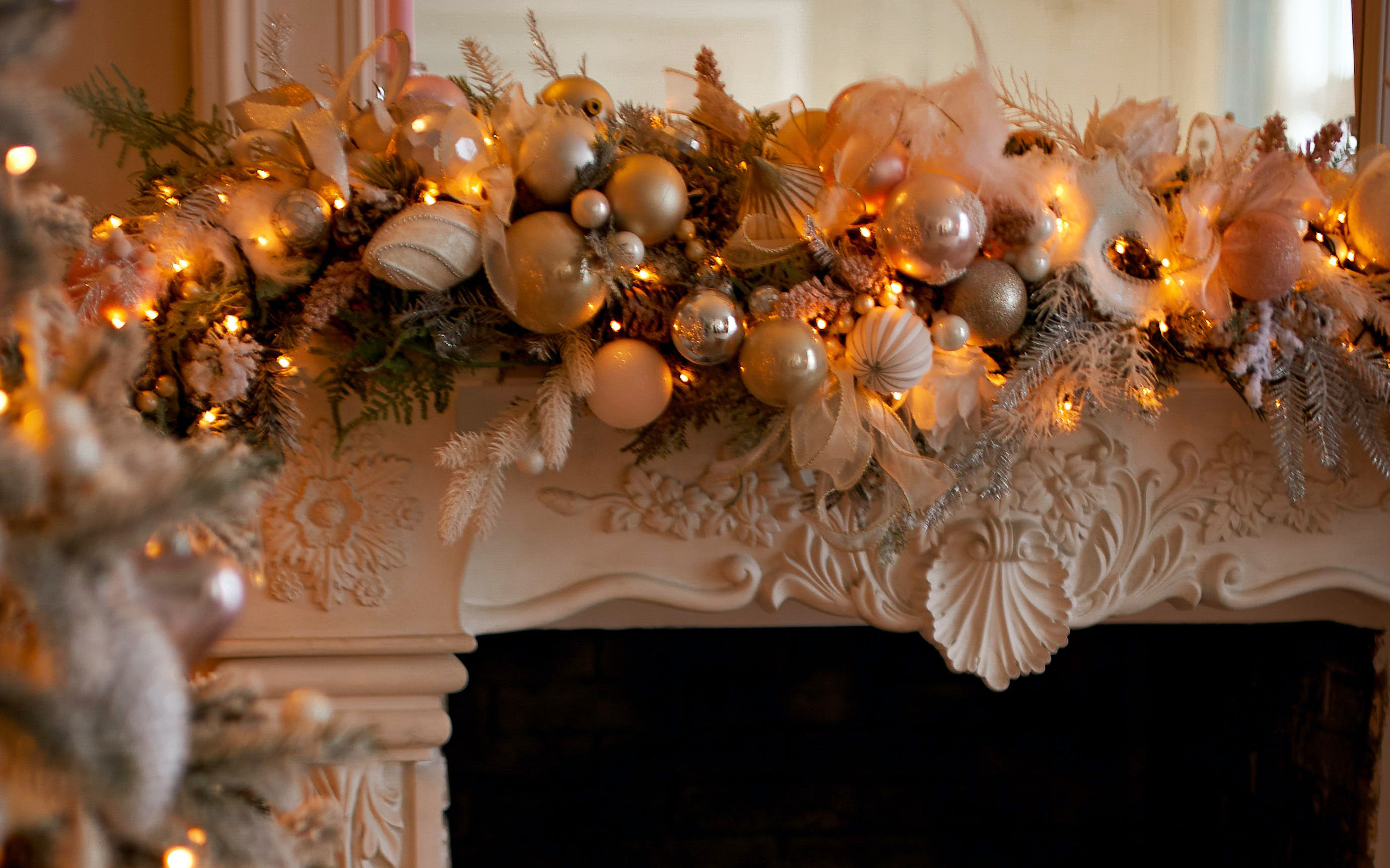 Ornate fireplace mantel opulently decorated with gold and silver ornaments and soft white mini lights