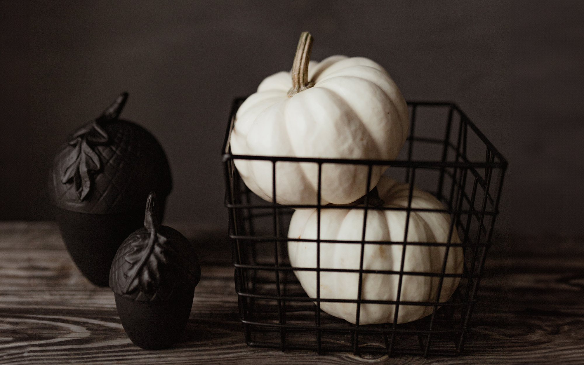 black acorn decorations, black wire basket filled with white pumpkins