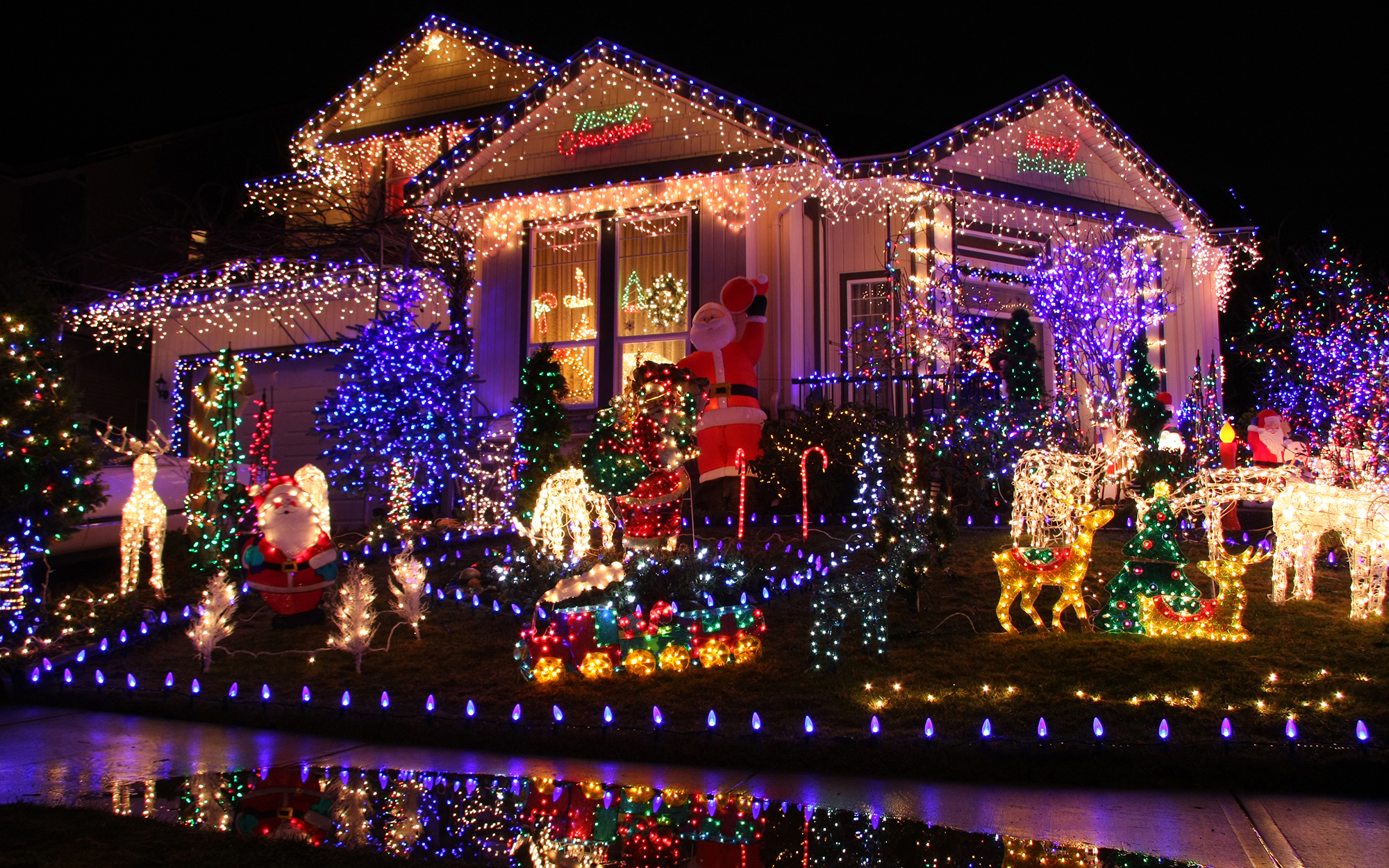 house at night elaborately decorated with colorful Christmas lights and decorations