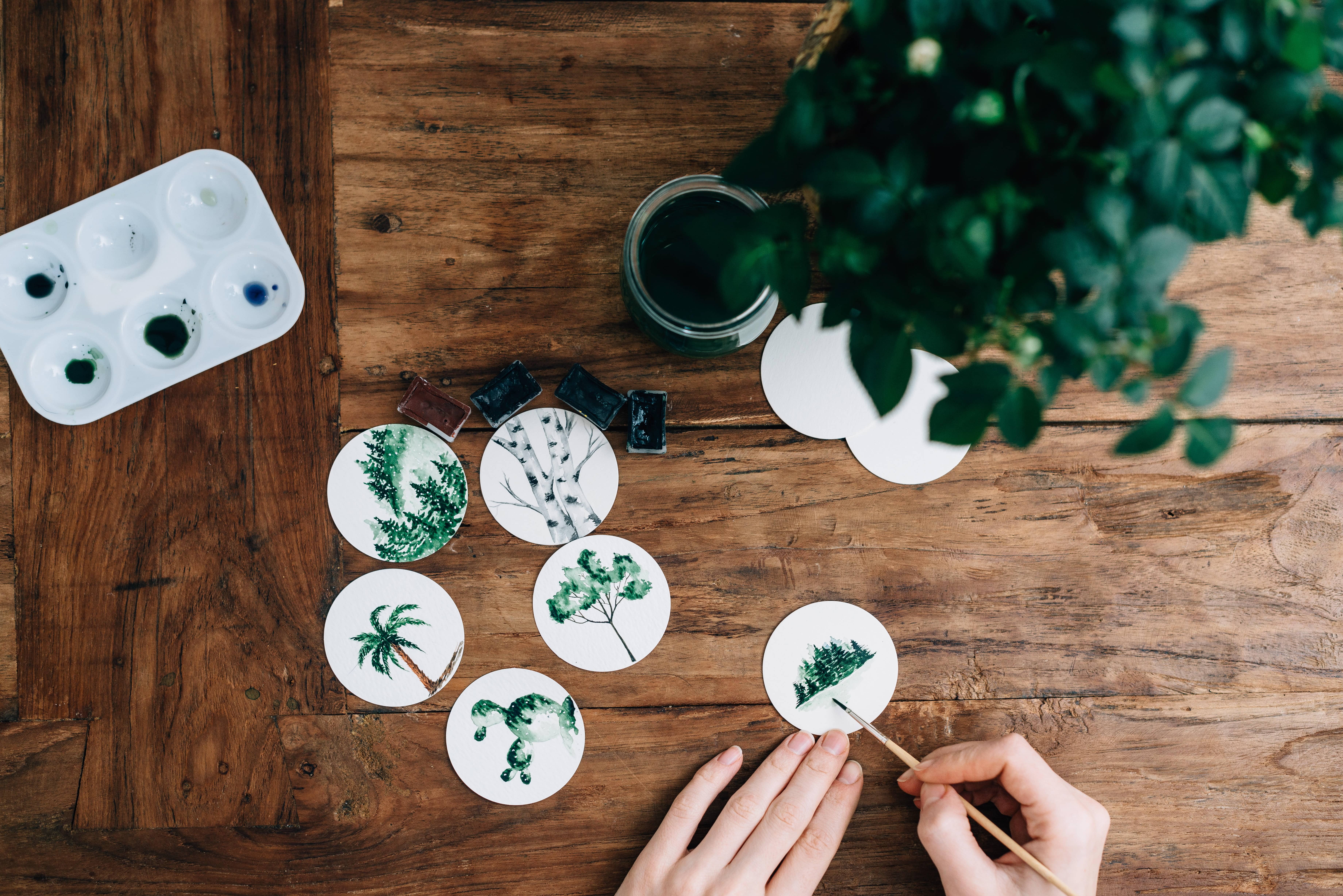 person painting plants with watercolor